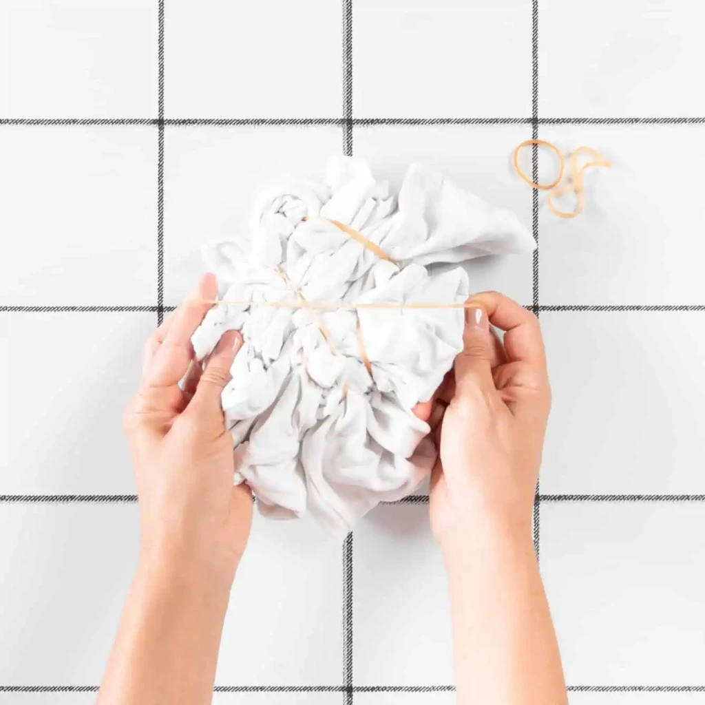 Owijanie zgniecionych ubrań gumkami.