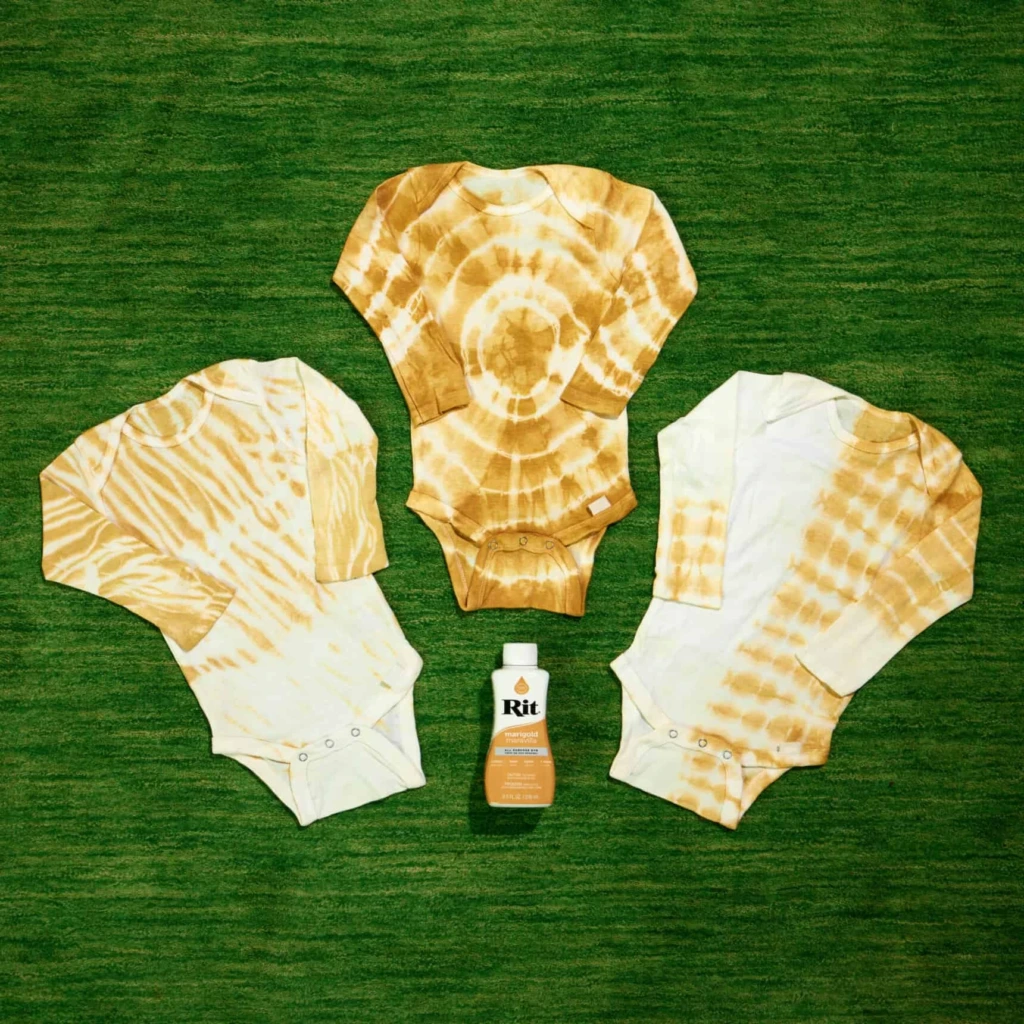 Jednoczęściowe kombinezony dla dzieci barwione metodą tie-dye w kolorze marigold