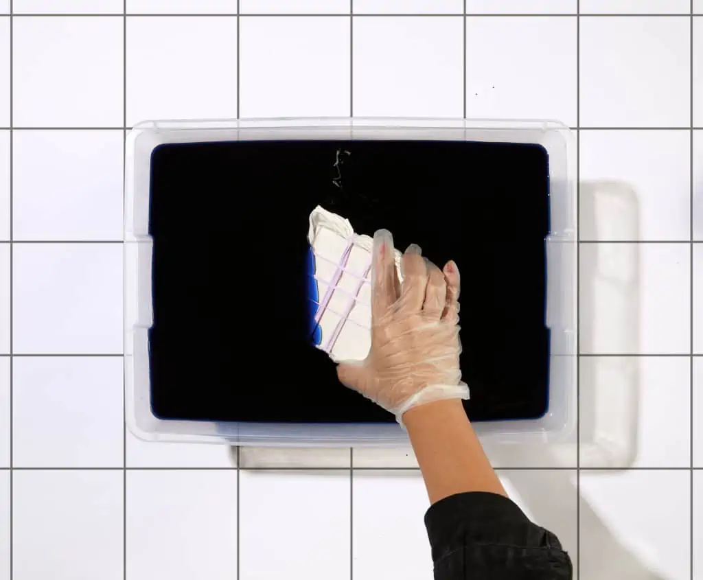 Wkładanie tkaniny do pojemnika z barwinikiem