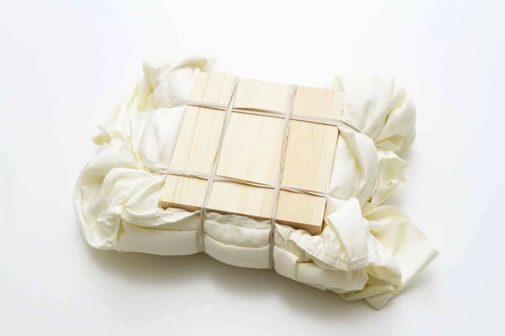 Owijanie tkaniny gumkami wokół klocka drewnianego